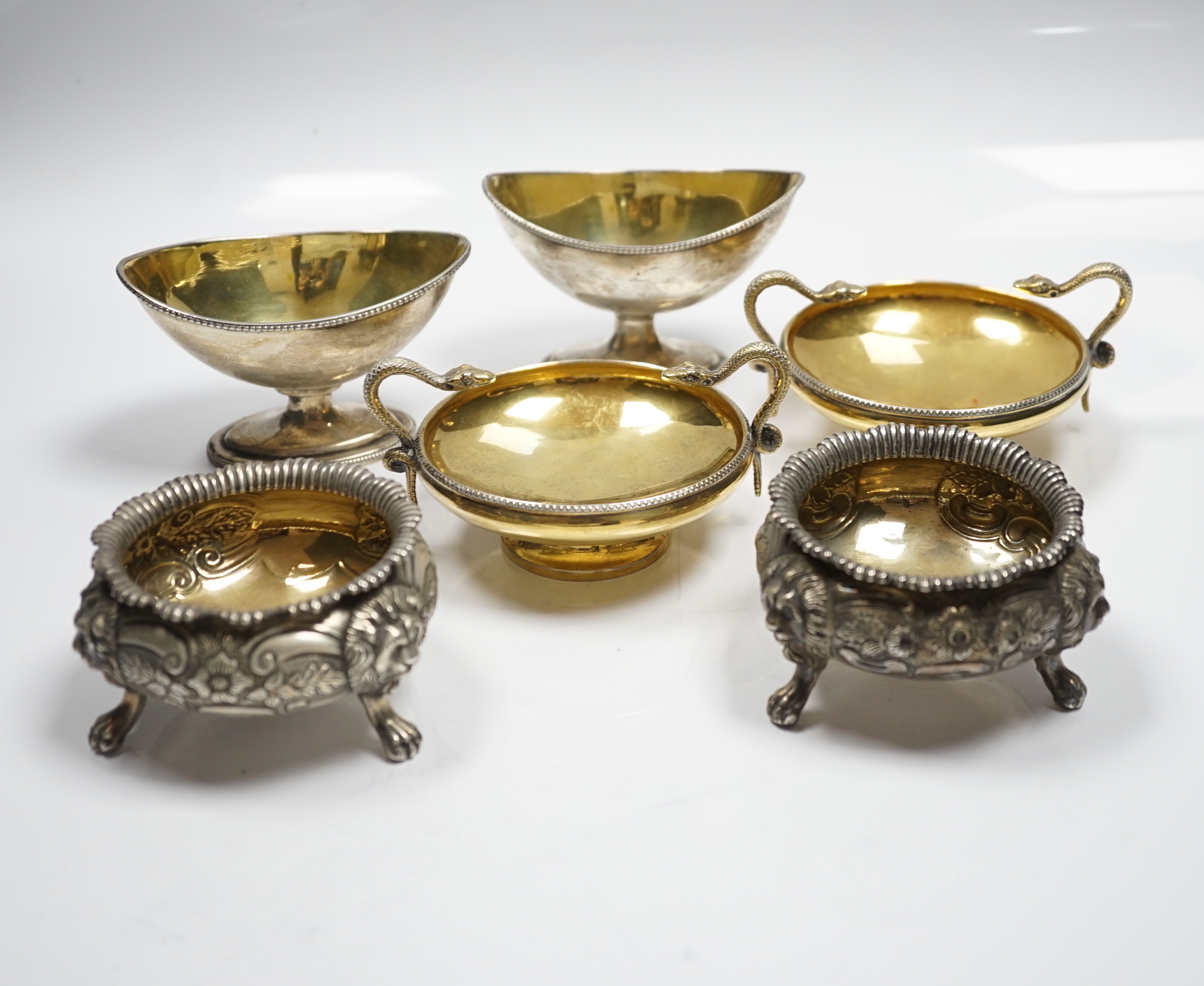 A pair of George V silver gilt shallow pedestal salts, with twin serpent handles, William Hutton & Sons, Ltd, Sheffield, 1928, width 11.8cm over handles, together with two matched pairs of Georgian silver salts, 20.3oz.